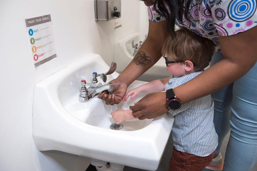 Provider and child washing hands