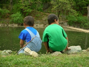 children next to pond outside