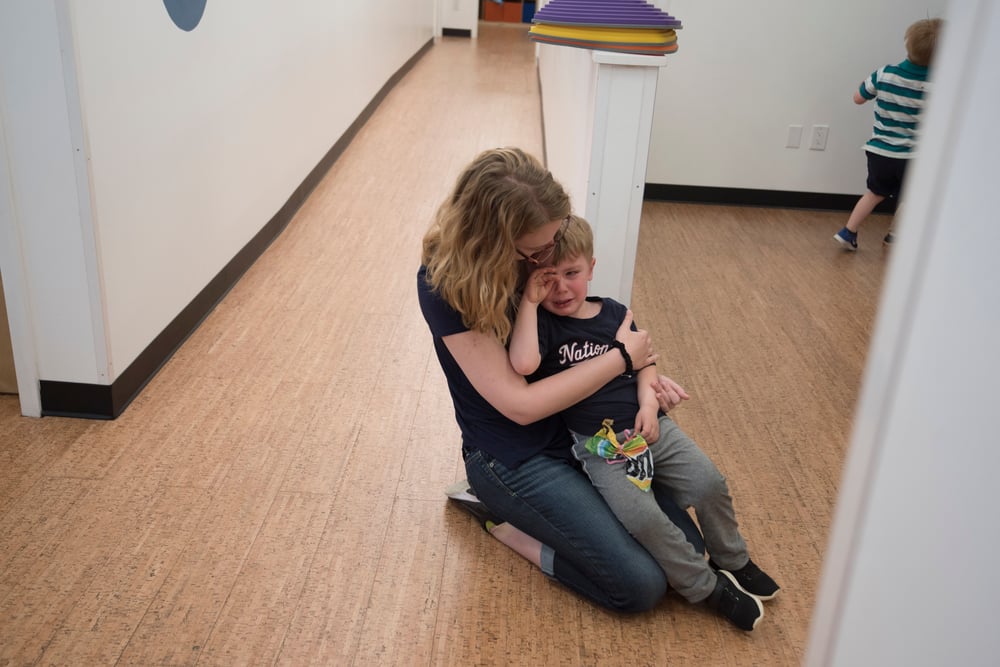 a teacher consoles a crying student