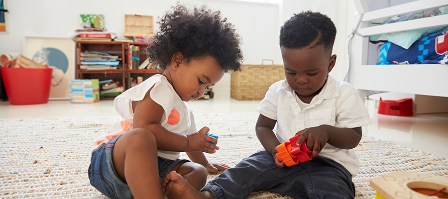 baby-boy-and-girl-playing-with-toys-in-playroom-to-PCPWKX2 (1)