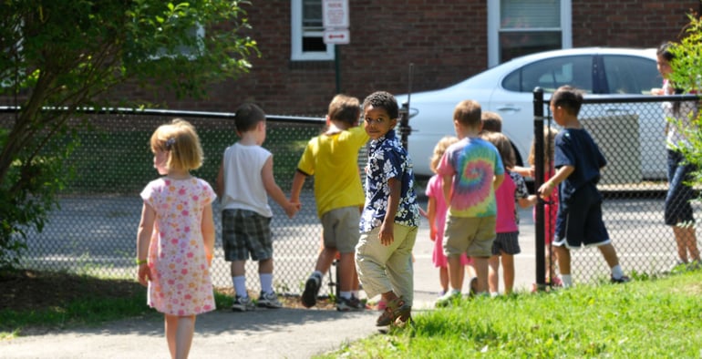 boy outside preschool looks toward camera before covid-19