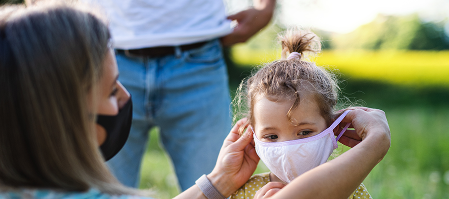 child wearing mask with mom