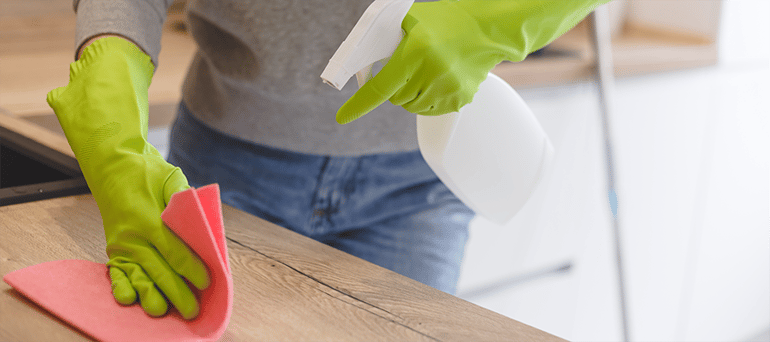 woman cleaning and disinfecting a table