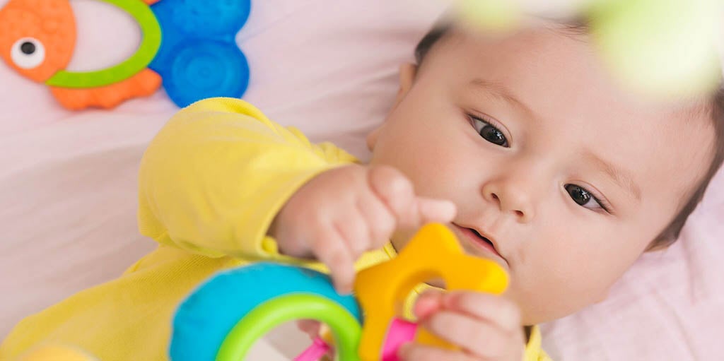 infant reaching for toy