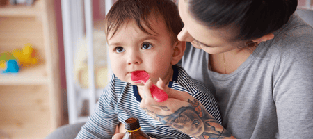 mother-feeding-boy-with-medicine-CVNY8NC