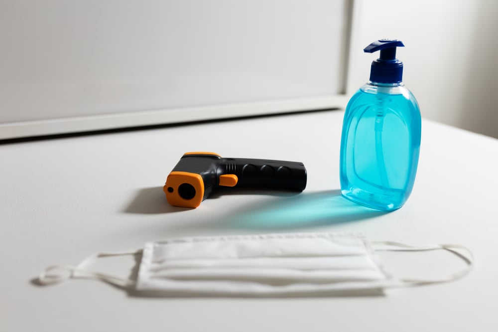 a thermometer, face mask and hand sanitizer