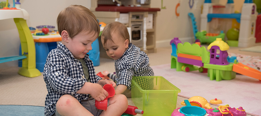 two young boys cleaning up toys