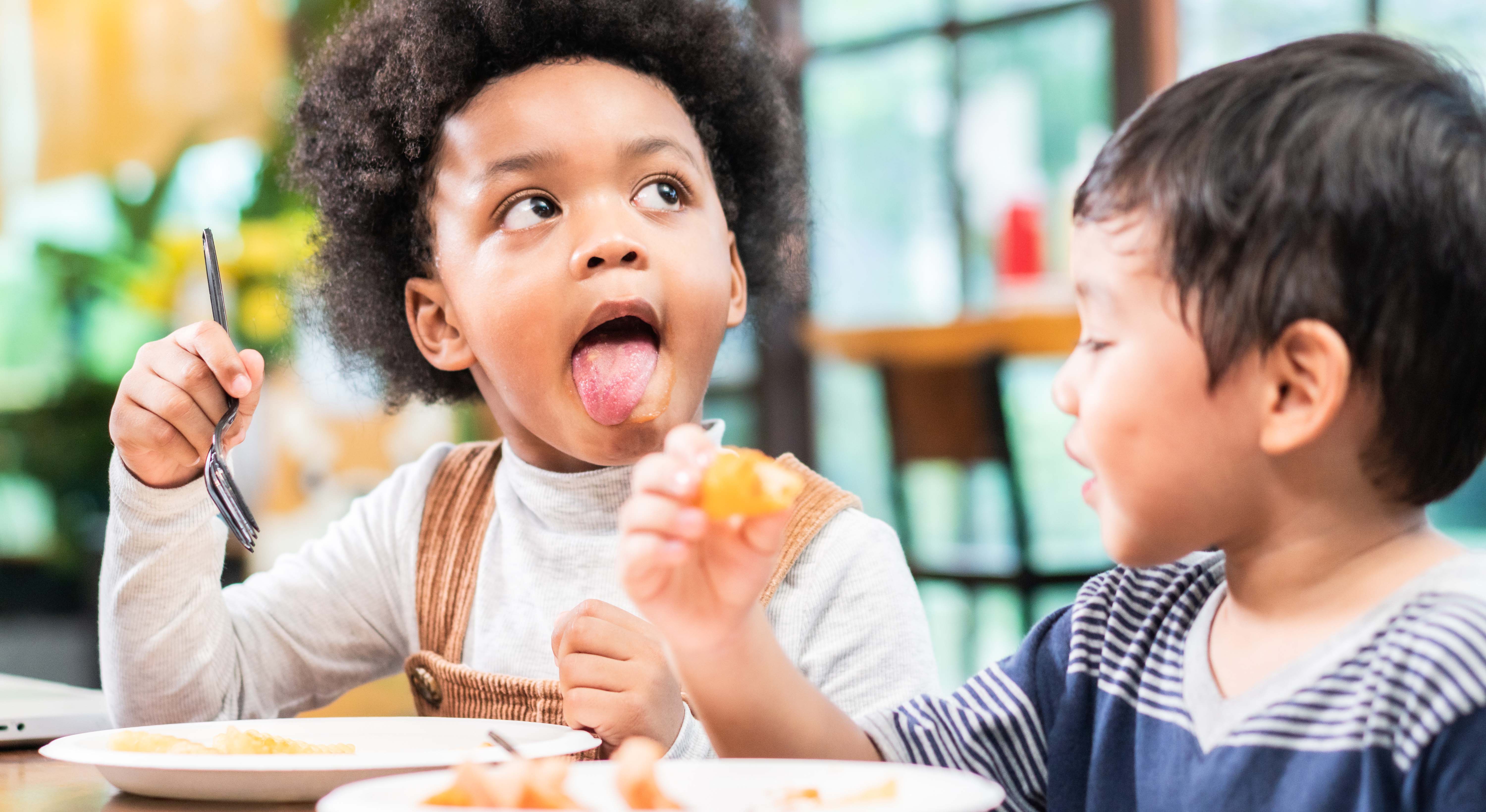 playful-kids-eating-snack-in-cafe-restaurant-2021-08-30-06-28-04-utc